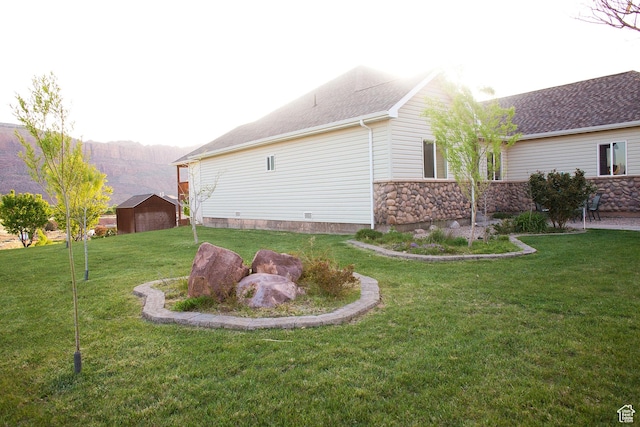 98 E Mt Peale Dr, Moab, UT 84532 - view of property exterior featuring stone siding, an outdoor structure, and a yard