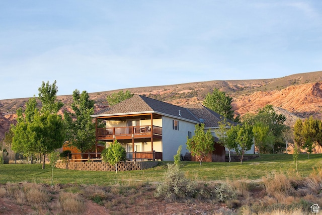 back of property featuring a yard and a deck with mountain view