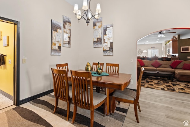 98 E Mt Peale Dr, Moab, UT 84532 - dining space with ceiling fan with notable chandelier, arched walkways, baseboards, and light wood-style floors