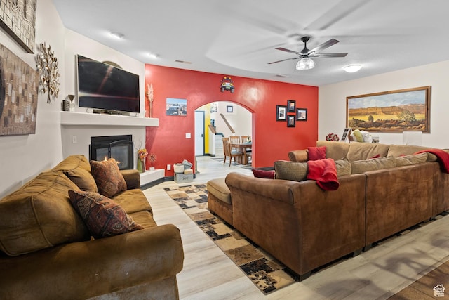 98 E Mt Peale Dr, Moab, UT 84532 - living area with arched walkways, visible vents, a glass covered fireplace, ceiling fan, and wood finished floors