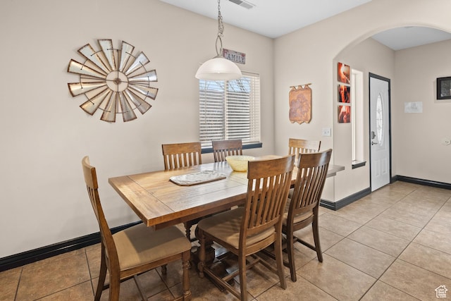 98 E Mt Peale Dr, Moab, UT 84532 - dining space featuring light tile patterned flooring, arched walkways, baseboards, and visible vents