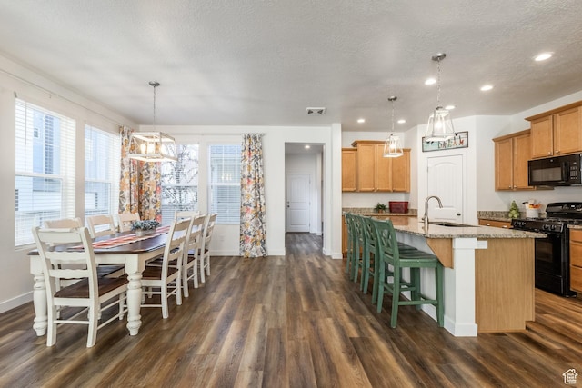 6321 W Moon Valley Dr, South Jordan, UT 84009 - kitchen featuring a sink, a kitchen island with sink, a textured ceiling, dark wood-style floors, and black appliances