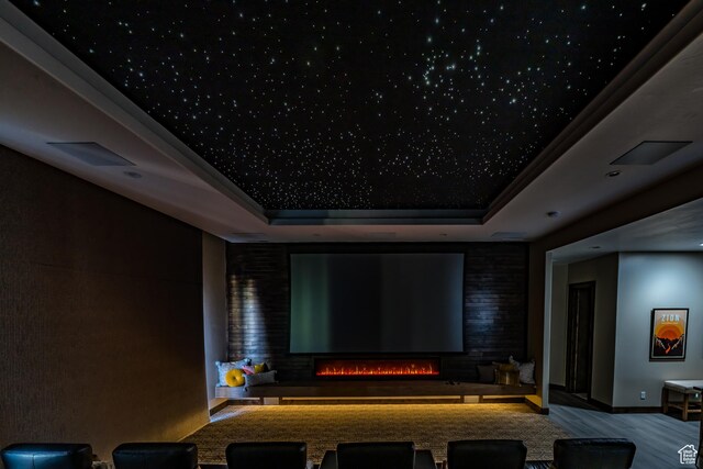 5024 W Nashoba Trl Unit 74, Hurricane, UT 84737 - cinema room with a tray ceiling, wood finished floors, baseboards, and a warm lit fireplace
