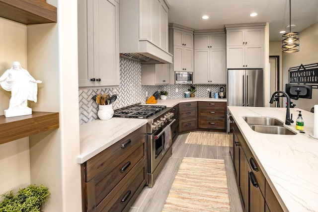 5024 W Nashoba Trl Unit 74, Hurricane, UT 84737 - kitchen with a sink, tasteful backsplash, high quality appliances, light stone countertops, and custom range hood