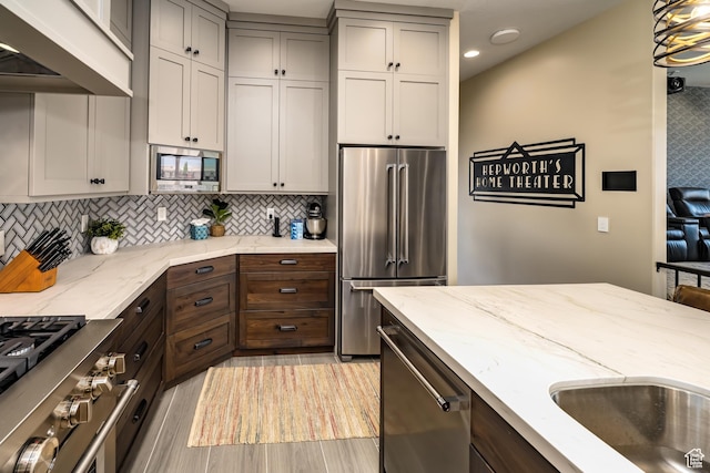 5024 W Nashoba Trl Unit 74, Hurricane, UT 84737 - kitchen with light stone countertops, light wood-style flooring, recessed lighting, premium appliances, and decorative backsplash