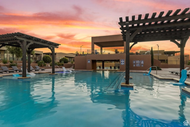 5024 W Nashoba Trl Unit 74, Hurricane, UT 84737 - pool at dusk with a pergola, a patio area, and a community pool