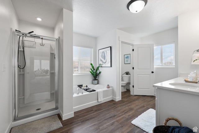 988 E Harrier St N, Eagle Mountain, UT 84005 - full bath featuring toilet, a stall shower, a garden tub, and wood finished floors
