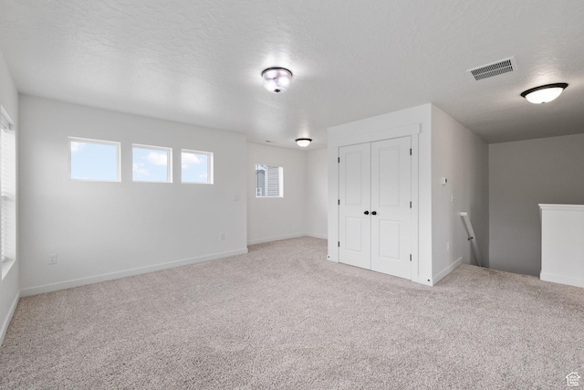 988 E Harrier St N, Eagle Mountain, UT 84005 - interior space with carpet floors, a textured ceiling, a healthy amount of sunlight, and visible vents