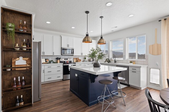 988 E Harrier St N, Eagle Mountain, UT 84005 - kitchen with white cabinets, light countertops, appliances with stainless steel finishes, and dark wood finished floors