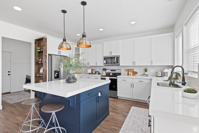 988 E Harrier St N, Eagle Mountain, UT 84005 - kitchen with blue cabinetry, white cabinetry, a sink, and stainless steel appliances