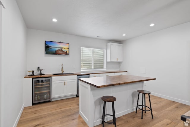 988 E Harrier St N, Eagle Mountain, UT 84005 - kitchen featuring white cabinetry, wine cooler, wooden counters, a sink, and dishwasher