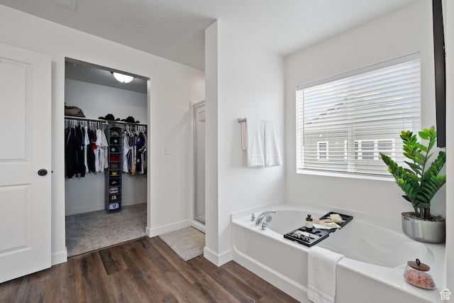 988 E Harrier St N, Eagle Mountain, UT 84005 - bathroom featuring a stall shower, wood finished floors, a spacious closet, a bath, and baseboards