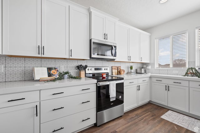 988 E Harrier St N, Eagle Mountain, UT 84005 - kitchen featuring light countertops, white cabinetry, tasteful backsplash, stainless steel appliances, and dark wood-type flooring