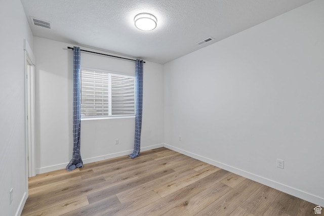 988 E Harrier St N, Eagle Mountain, UT 84005 - empty room with visible vents, a textured ceiling, baseboards, and wood finished floors