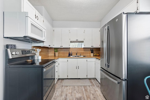 510 S Grant E, Ogden, UT 84404 - kitchen featuring white cabinetry, light wood-type flooring, stainless steel appliances, a textured ceiling, and a sink