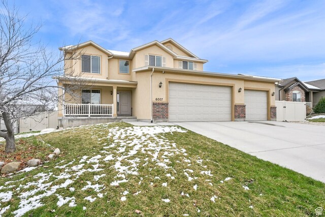 6007 W Jargon Way, Salt Lake City, UT 84118 - view of front of home featuring driveway, stucco siding, fence, a garage, and a porch