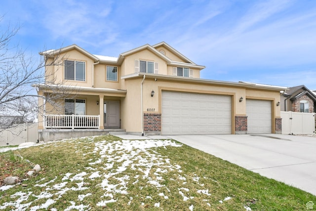 6007 W Jargon Way, Salt Lake City, UT 84118 - view of front of property with covered porch, concrete driveway, stucco siding, fence, and brick siding