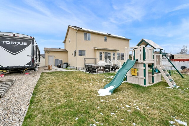 6007 W Jargon Way, Salt Lake City, UT 84118 - rear view of property featuring fence, a playground, central AC, stucco siding, and a yard