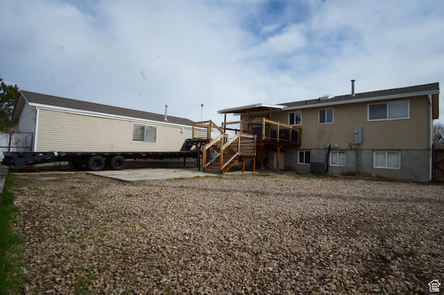 7598 S 2290 W, West Jordan, UT 84084 - rear view of house featuring stairs, a wooden deck, and a patio area