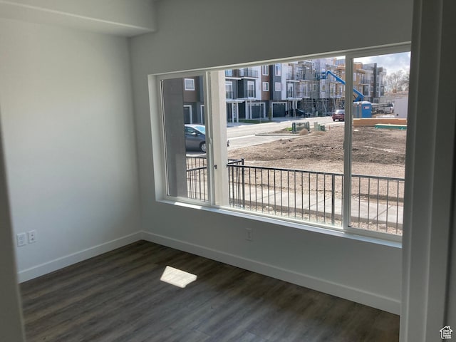 spare room with a wealth of natural light and wood finished floors