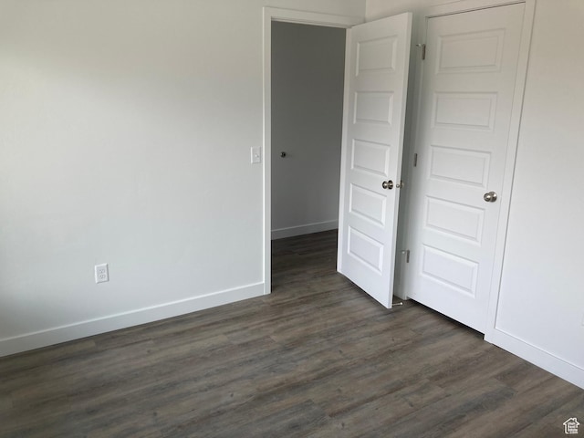 unfurnished bedroom featuring dark wood finished floors and baseboards