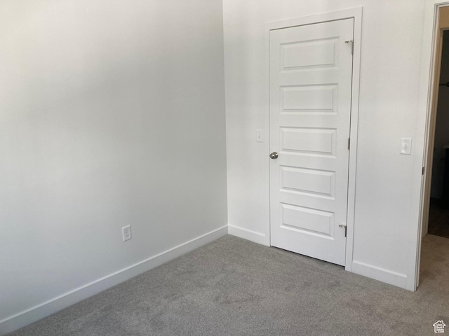 carpeted spare room with baseboards