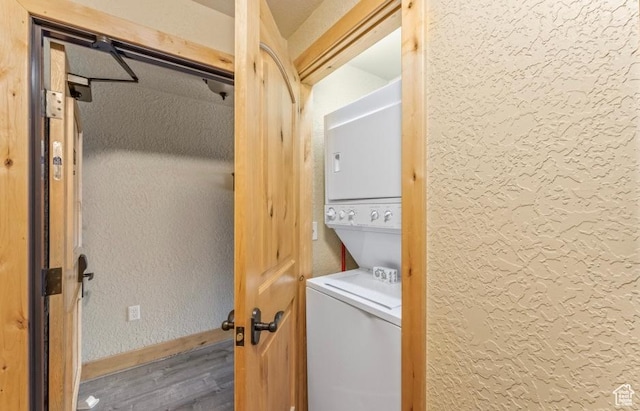 2669 Canyons Resort Dr Unit 312, Park City, UT 84098 - clothes washing area with wood finished floors, stacked washing maching and dryer, laundry area, baseboards, and a textured wall