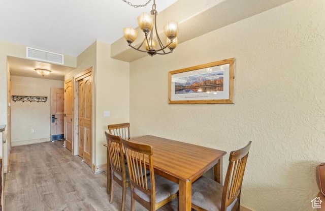 2669 Canyons Resort Dr Unit 312, Park City, UT 84098 - dining room with visible vents, light wood finished floors, baseboards, a textured wall, and an inviting chandelier