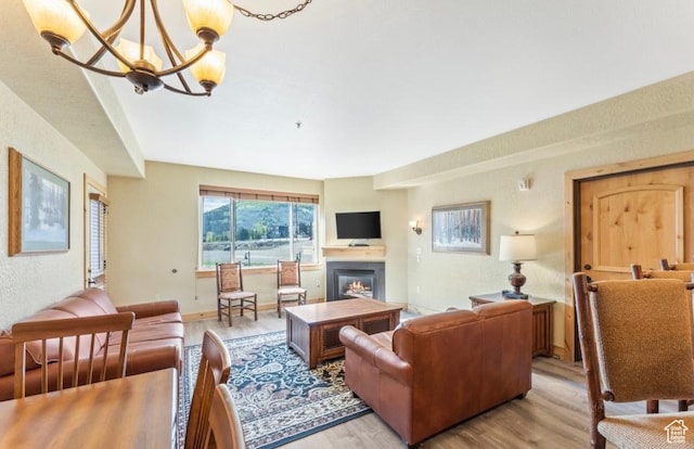 2669 Canyons Resort Dr Unit 312, Park City, UT 84098 - living area with baseboards, a notable chandelier, a glass covered fireplace, and light wood-type flooring
