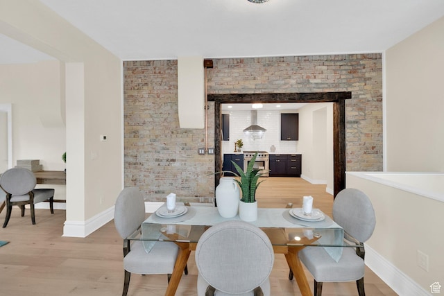 dining room featuring light wood finished floors and baseboards
