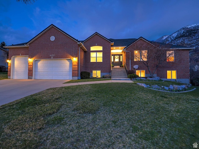 view of front of house with driveway, a front yard, an attached garage, and brick siding