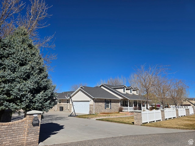 view of front of house featuring a front lawn, fence, a garage, and concrete driveway