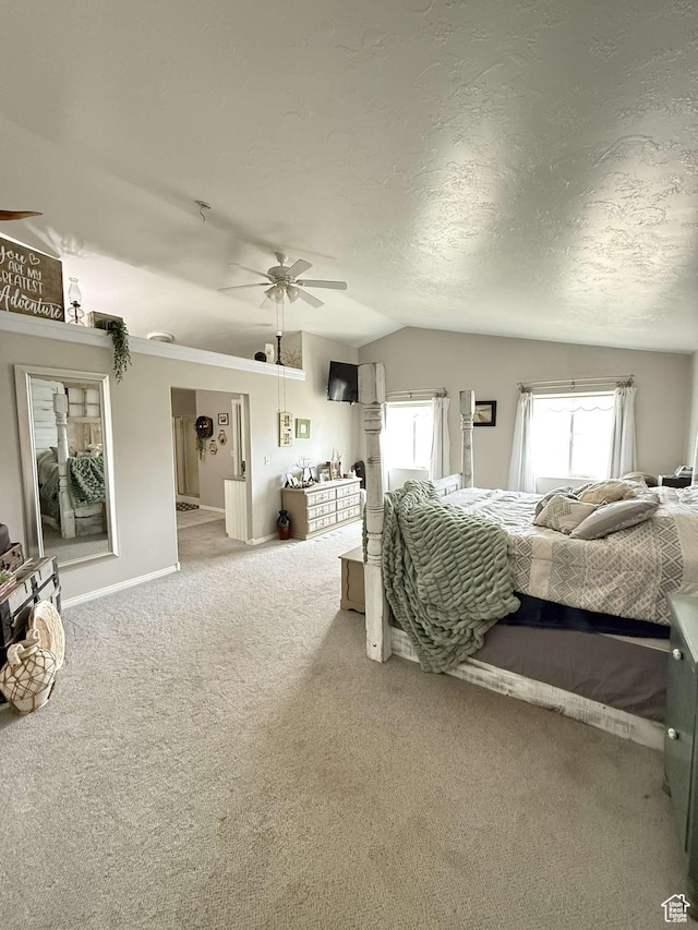 bedroom with a textured ceiling, carpet flooring, a ceiling fan, and lofted ceiling