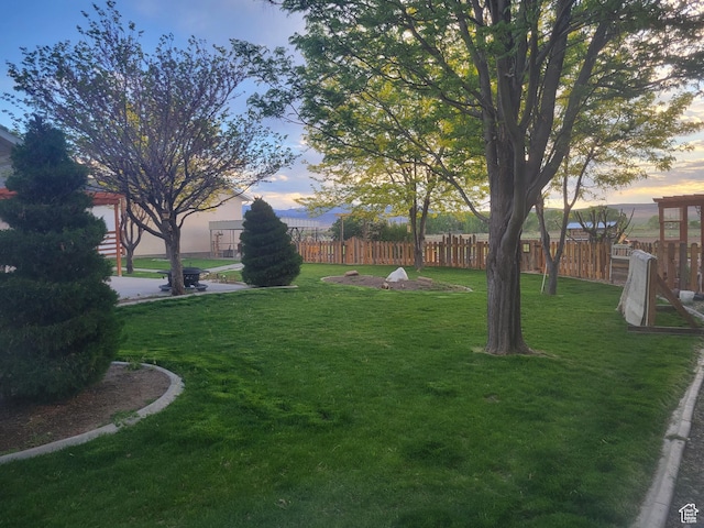 yard at dusk featuring fence