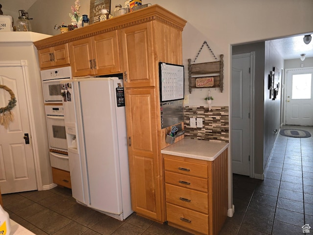 kitchen featuring baseboards, light countertops, a warming drawer, white refrigerator with ice dispenser, and decorative backsplash