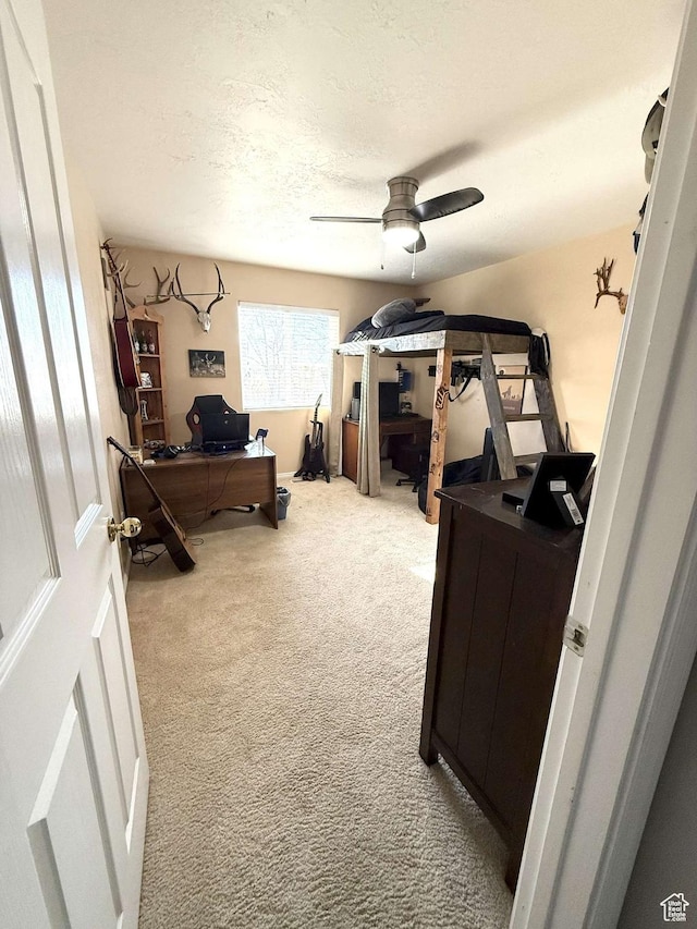bedroom featuring carpet, a textured ceiling, and a ceiling fan