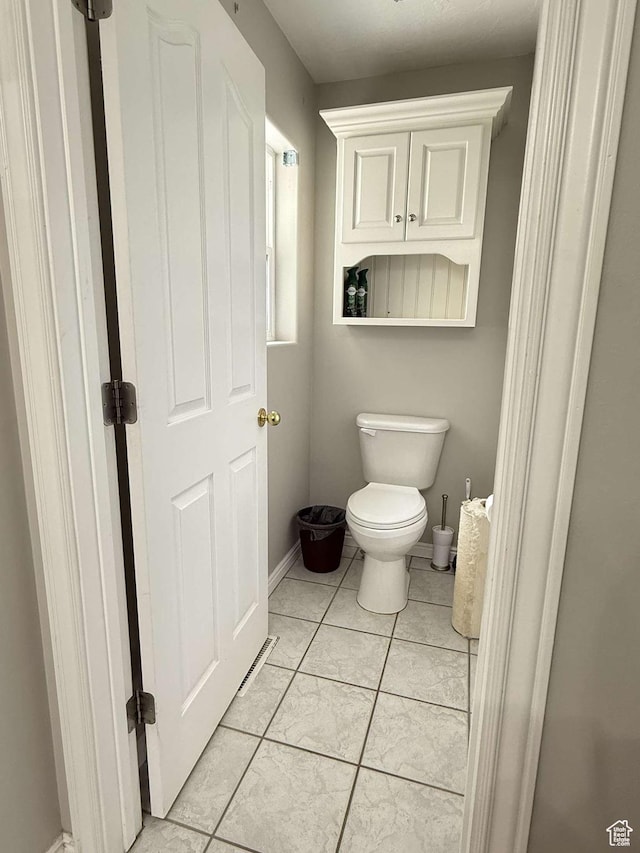 bathroom with tile patterned floors, toilet, and baseboards