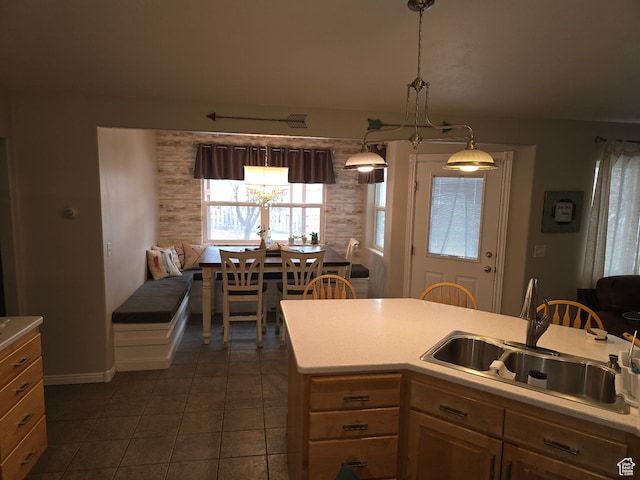 kitchen featuring light countertops, a chandelier, a sink, and dark tile patterned floors