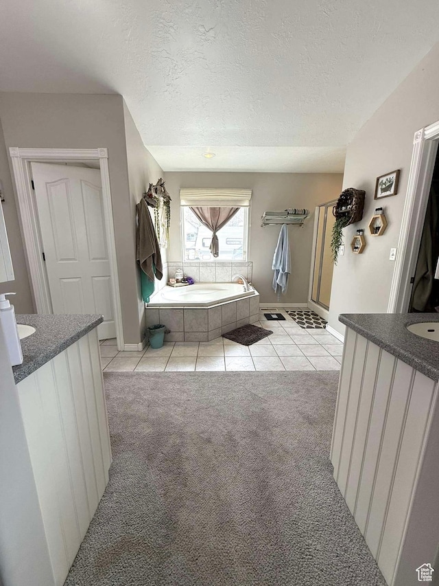 bathroom featuring a textured ceiling, vanity, and a garden tub