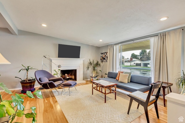 1055 E Chevy Chase Dr S, Murray, UT 84117 - living area featuring baseboards, a warm lit fireplace, wood finished floors, and recessed lighting