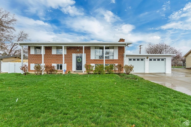 raised ranch featuring fence, an attached garage, a front yard, brick siding, and driveway