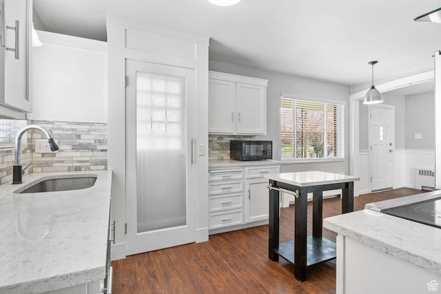 2928 S 575 W, Bountiful, UT 84010 - kitchen with white cabinets, a sink, tasteful backsplash, radiator, and black microwave