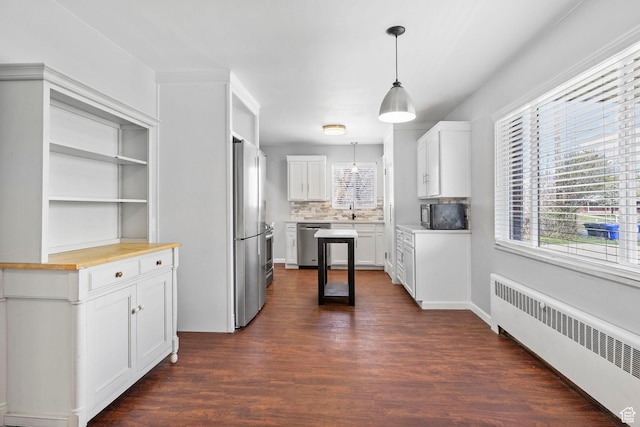2928 S 575 W, Bountiful, UT 84010 - kitchen with white cabinets, pendant lighting, stainless steel appliances, radiator, and dark wood-type flooring