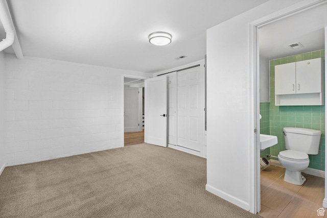 2928 S 575 W, Bountiful, UT 84010 - unfurnished bedroom with visible vents, tile walls, a closet, carpet floors, and ensuite bathroom