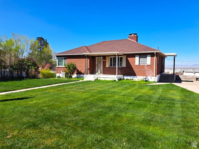 single story home with brick siding, a chimney, and a front lawn