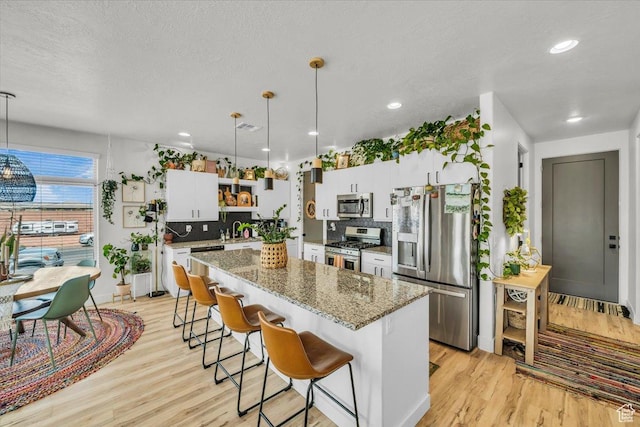 687 S Guy Ln Unit 1, Ivins, UT 84738 - kitchen with light wood-style flooring, a breakfast bar, stainless steel appliances, a kitchen island, and open shelves