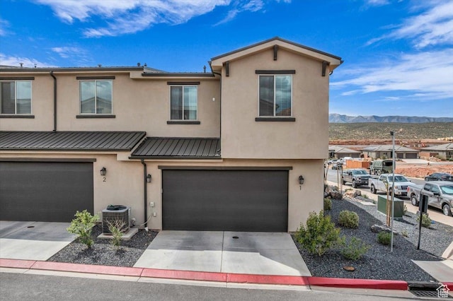 687 S Guy Ln Unit 1, Ivins, UT 84738 - townhome / multi-family property with central AC unit, concrete driveway, stucco siding, and an attached garage
