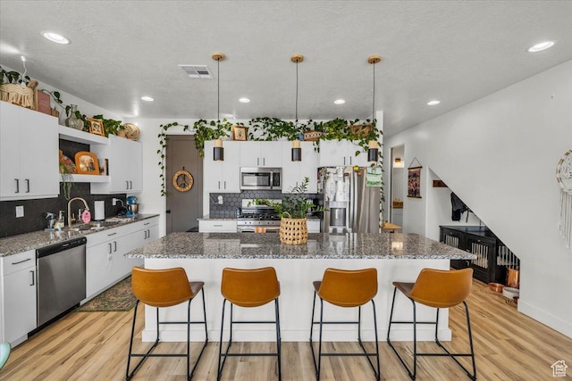 687 S Guy Ln Unit 1, Ivins, UT 84738 - kitchen with light wood-style flooring, stainless steel appliances, a kitchen island, and open shelves