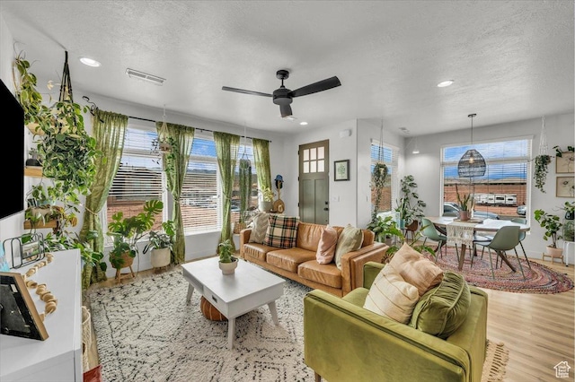 687 S Guy Ln Unit 1, Ivins, UT 84738 - living room featuring a textured ceiling, visible vents, ceiling fan, and wood finished floors
