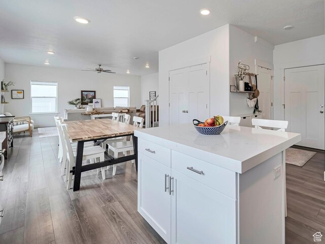kitchen featuring light countertops, wood finished floors, ceiling fan, and a kitchen island